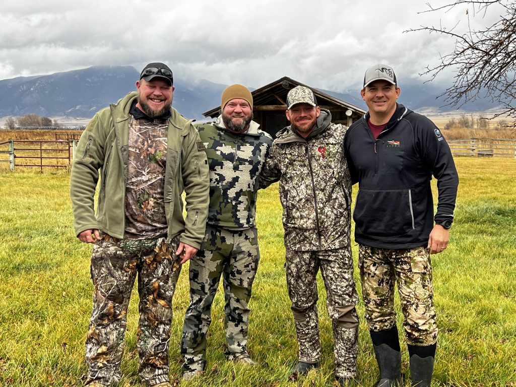 Soldiers on a Wounded Warriors hunt standing together in a field.