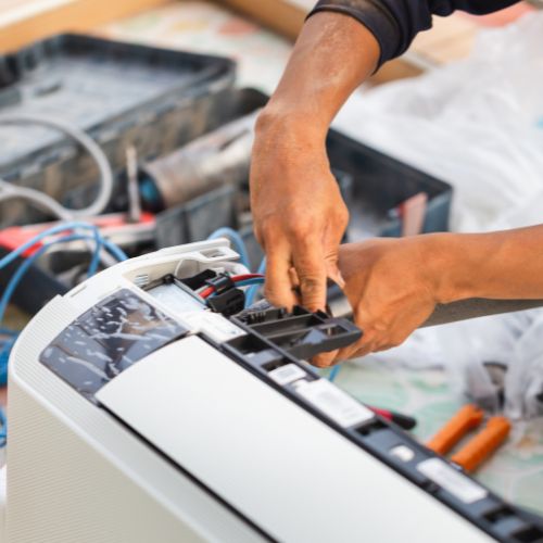 A technician's hands as they repair an Air Conditioner