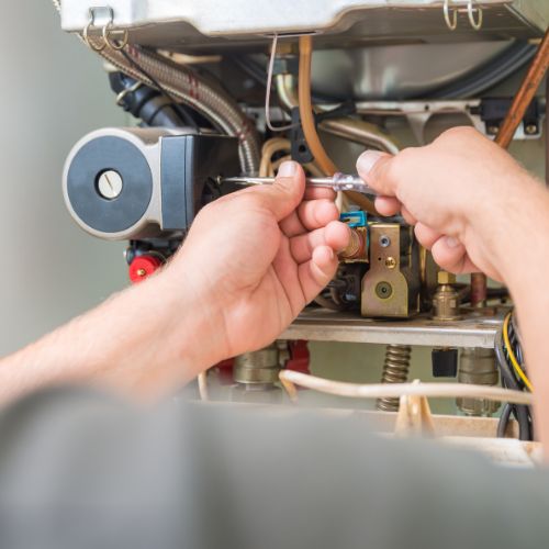 A service technician repairs a furnace